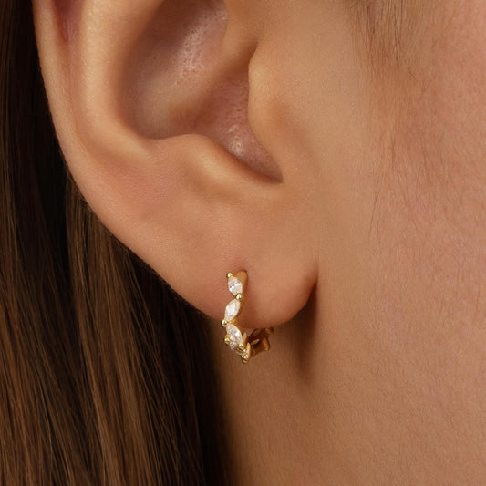 a close up of a person wearing a pair of earrings