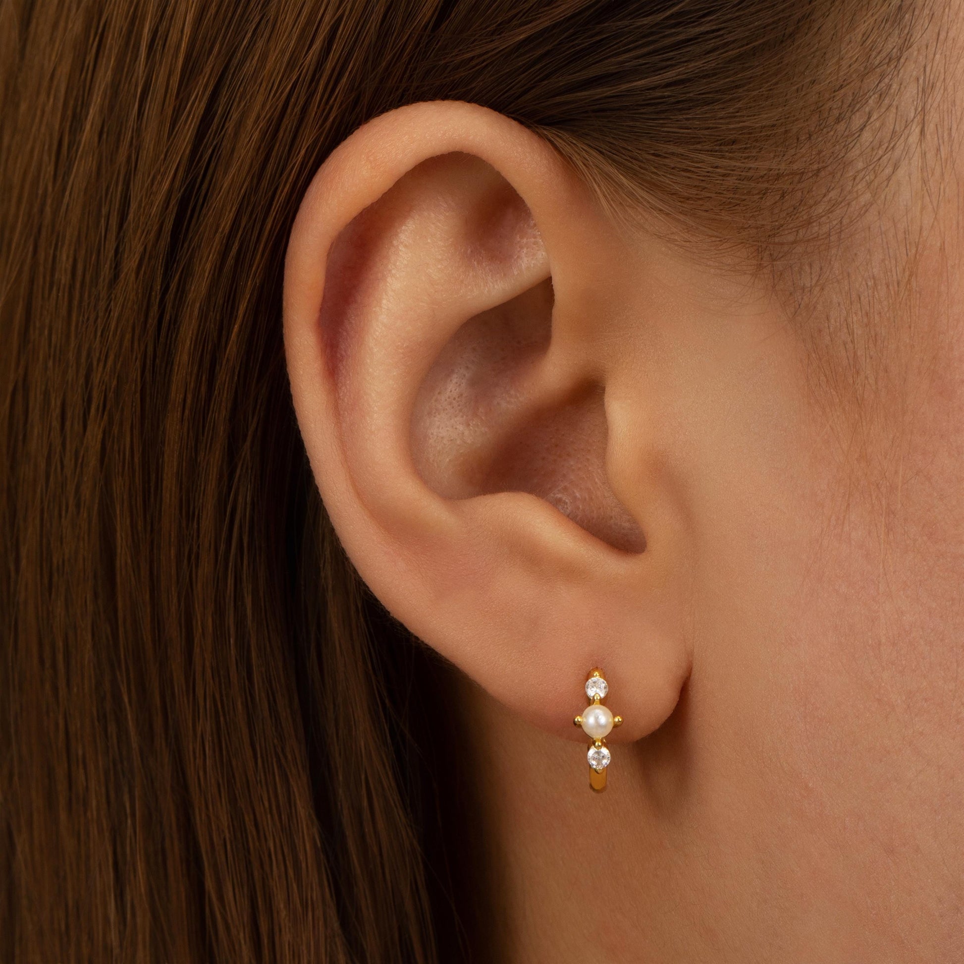 a close up of a person wearing a pair of earrings