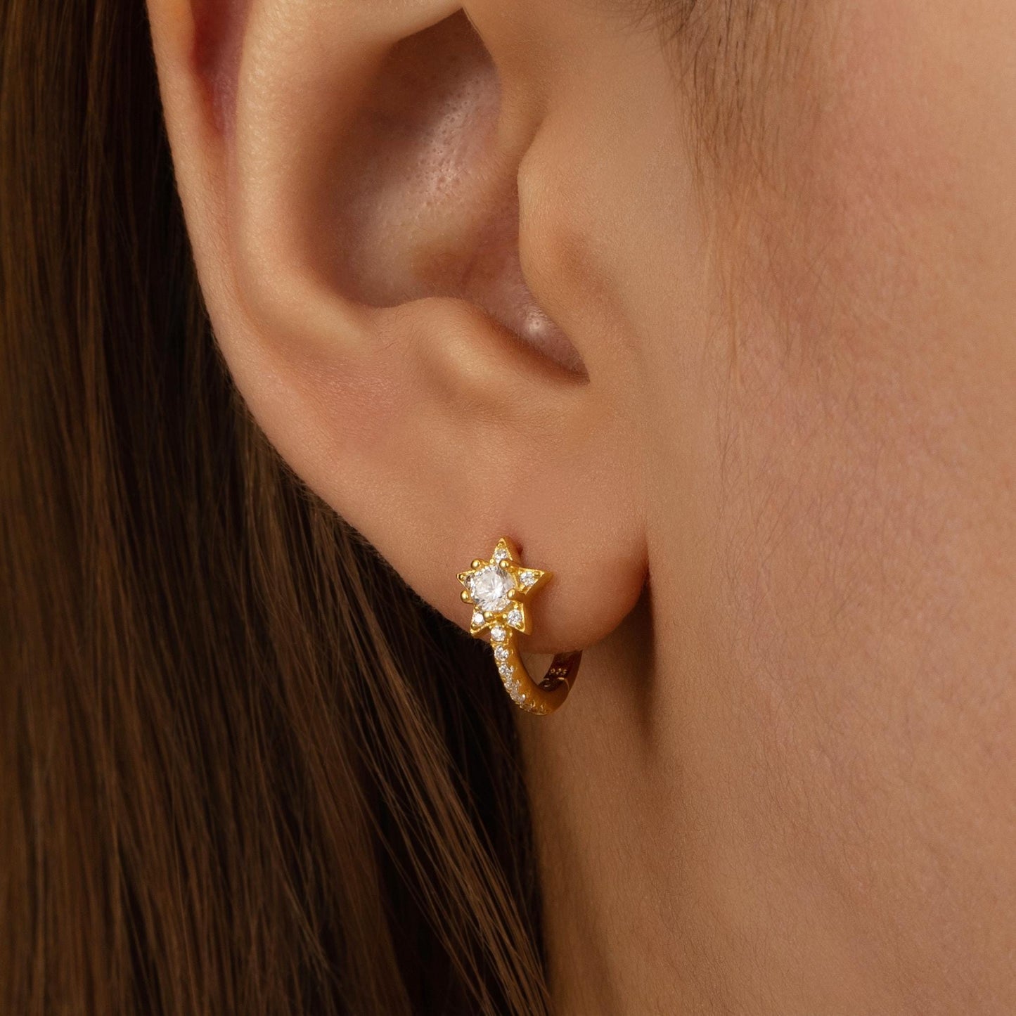 a close up of a person wearing a pair of earrings