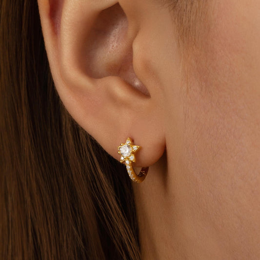 a close up of a person wearing a pair of earrings
