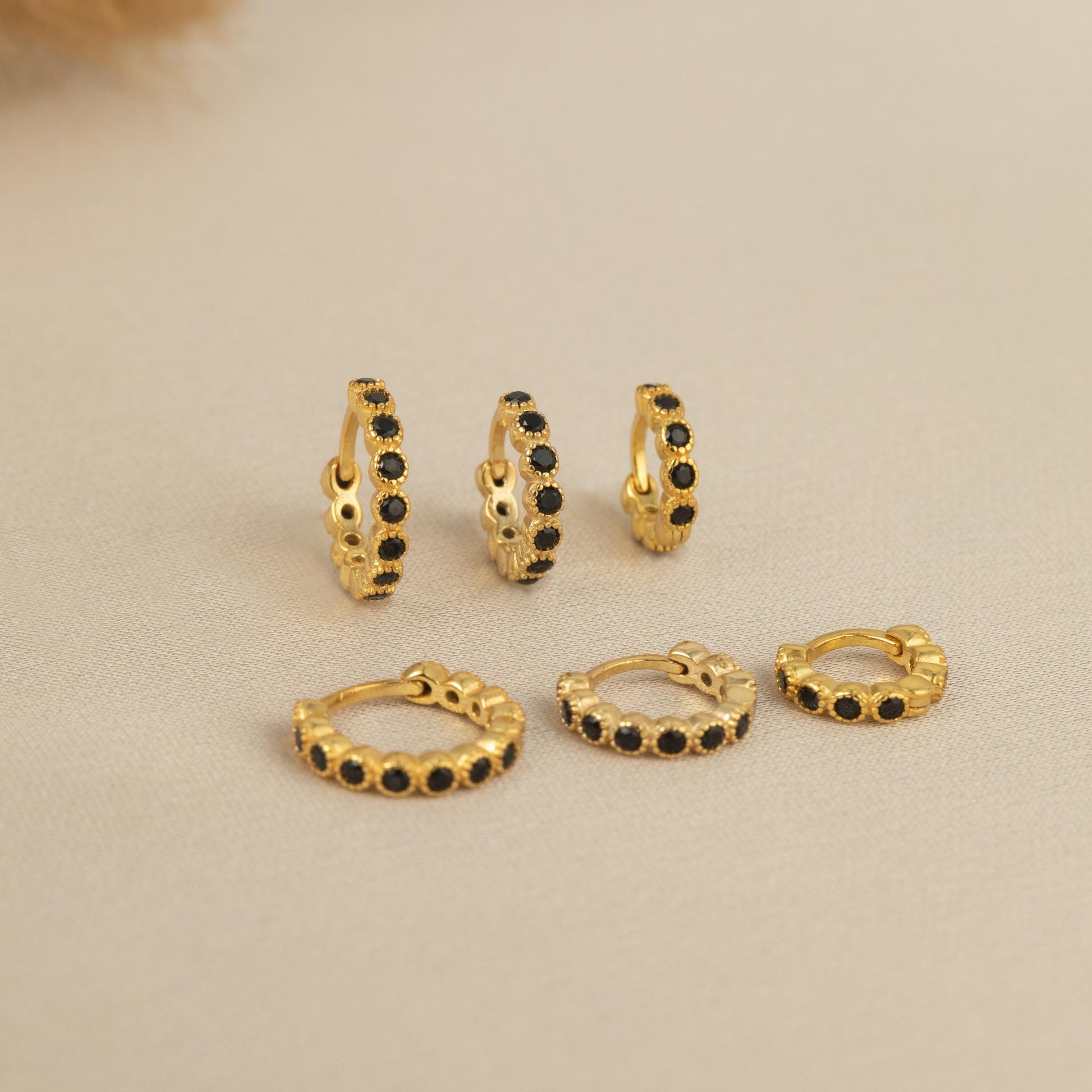 a set of four pairs of gold and black diamond hoop earrings