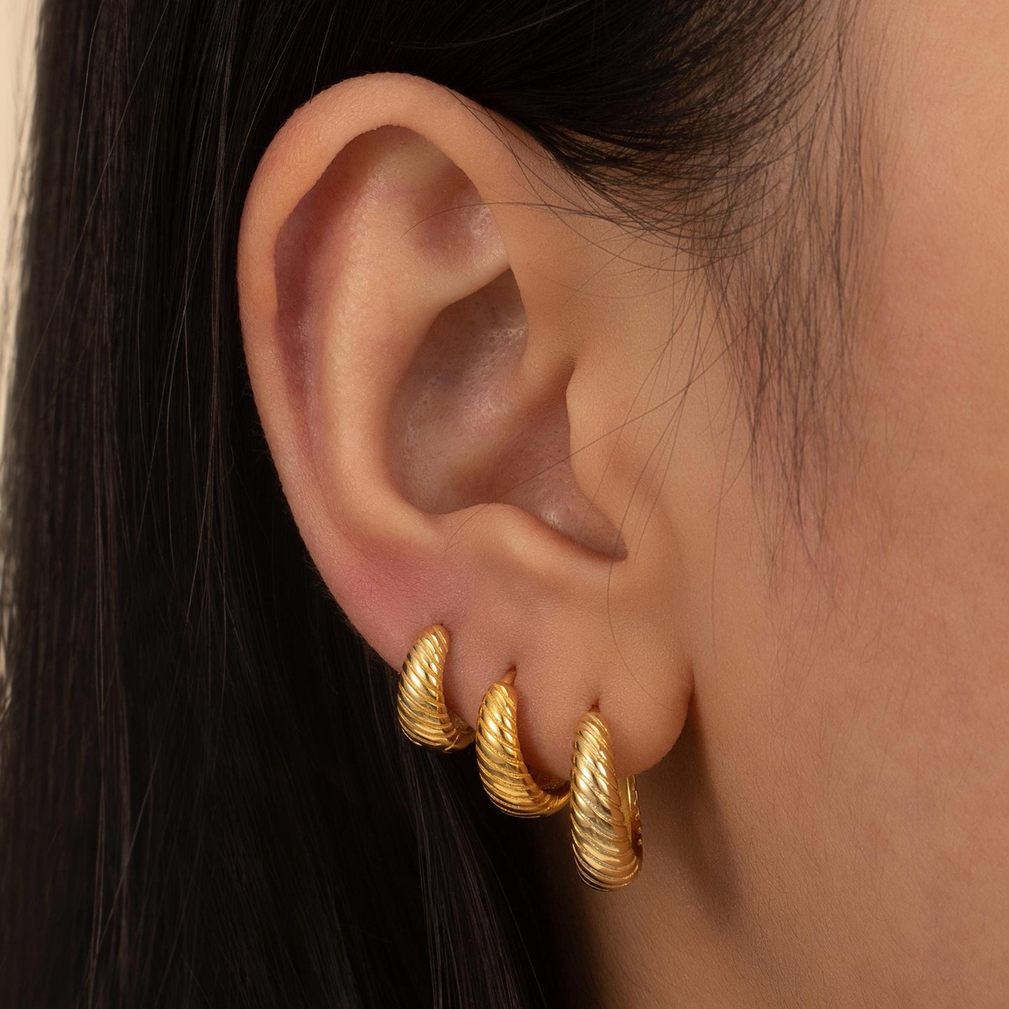a close up of a person wearing a pair of earrings
