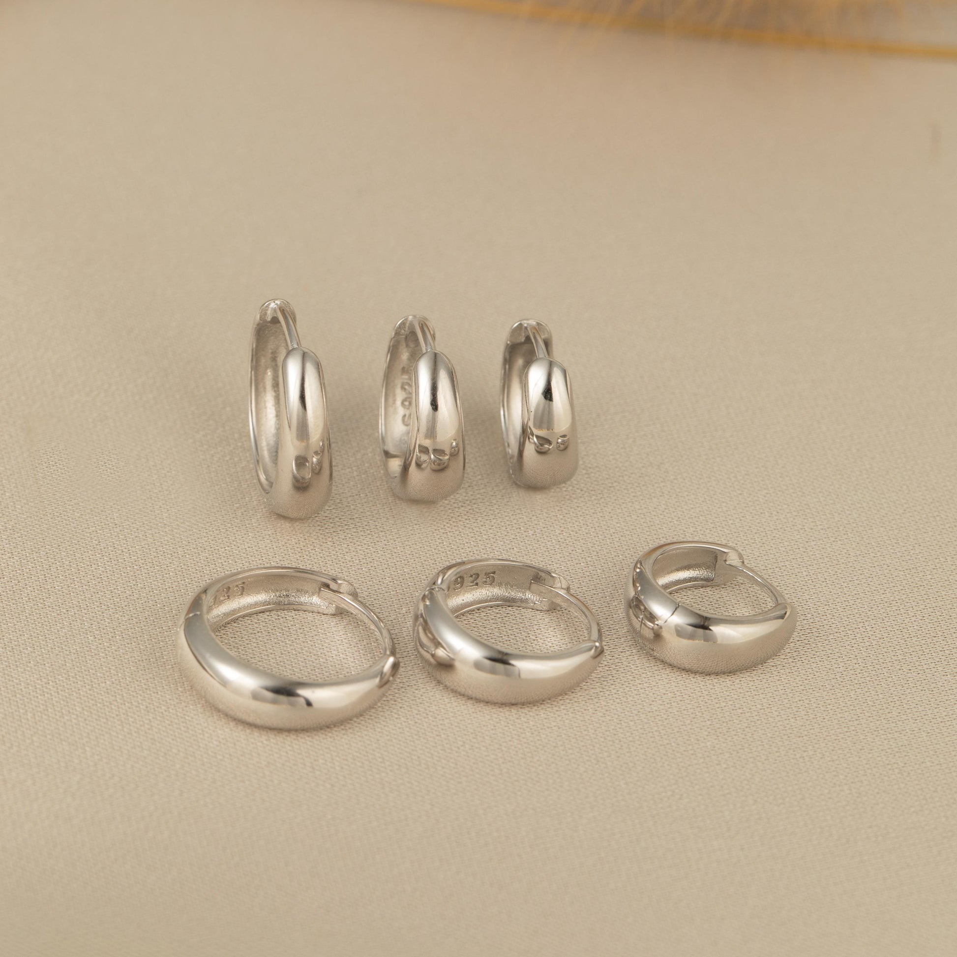 a group of silver rings and a pair of earrings