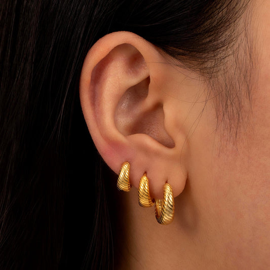 a close up of a person wearing a pair of earrings