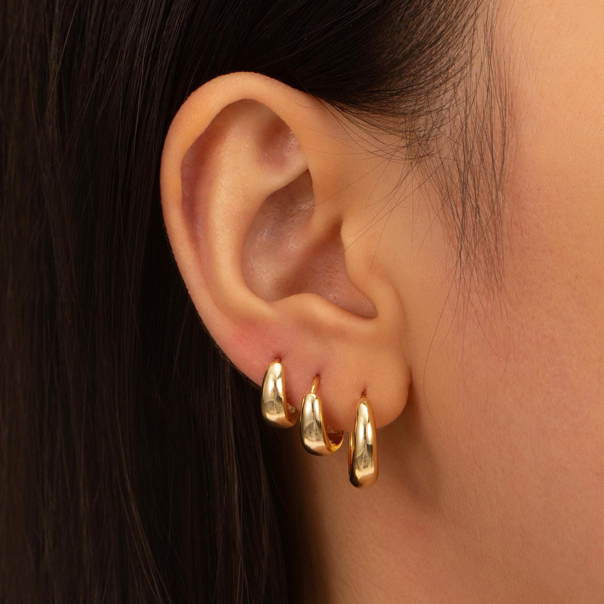 a close up of a person wearing a pair of earrings
