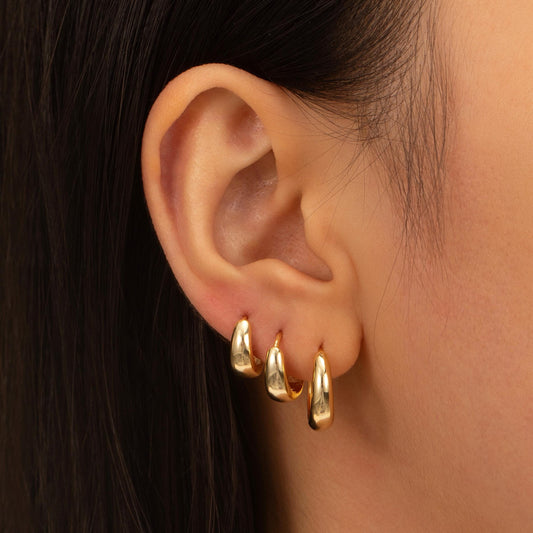 a close up of a person wearing a pair of earrings