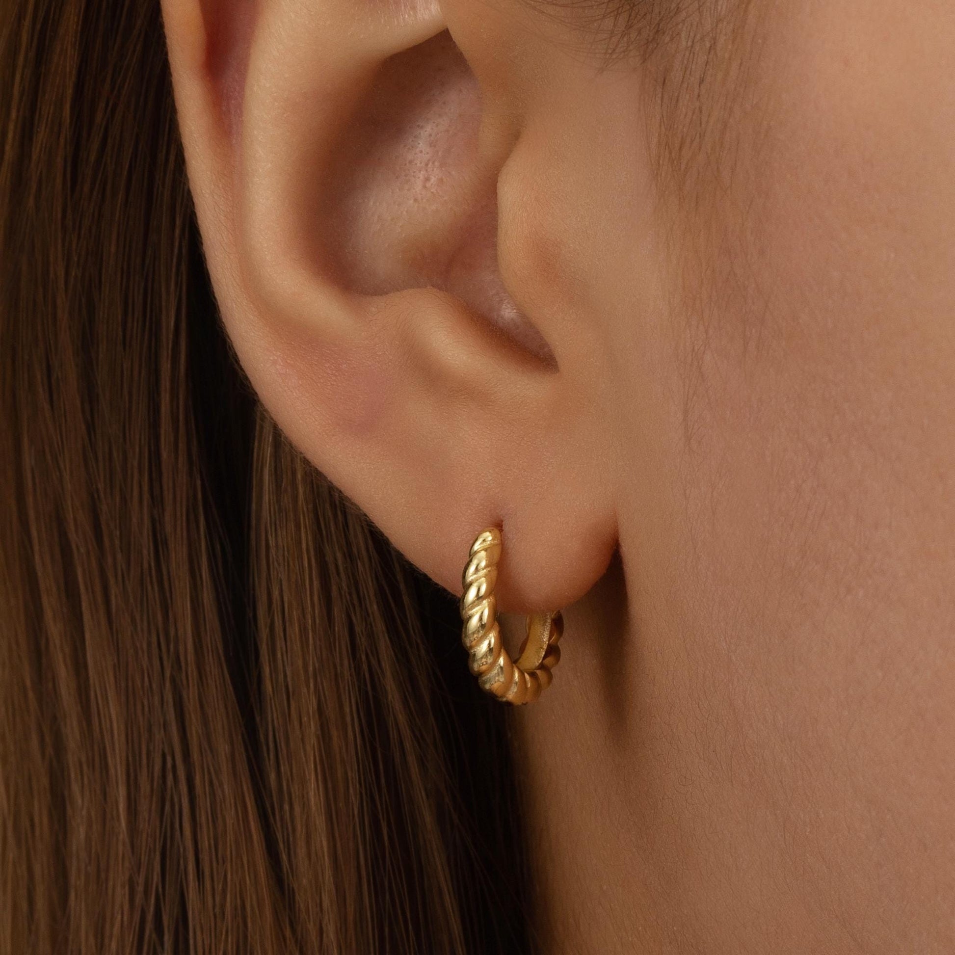 a close up of a person wearing a pair of earrings