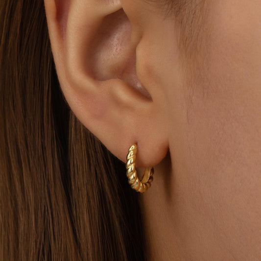 a close up of a person wearing a pair of earrings