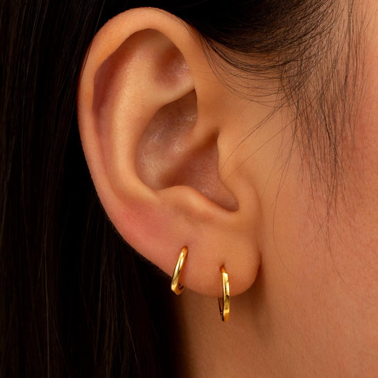 a close up of a person wearing a pair of earrings
