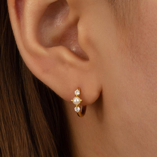 a close up of a person wearing a pair of earrings