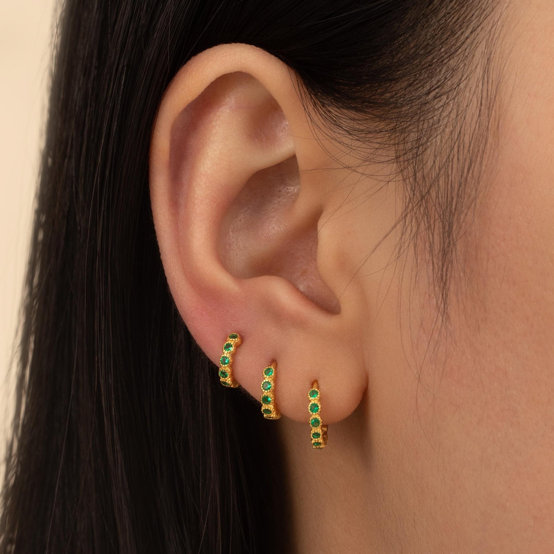 a close up of a person wearing a pair of earrings