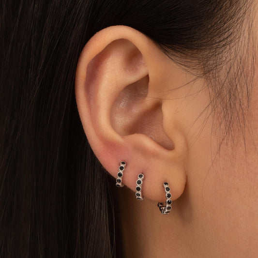 a close up of a person wearing a pair of earrings