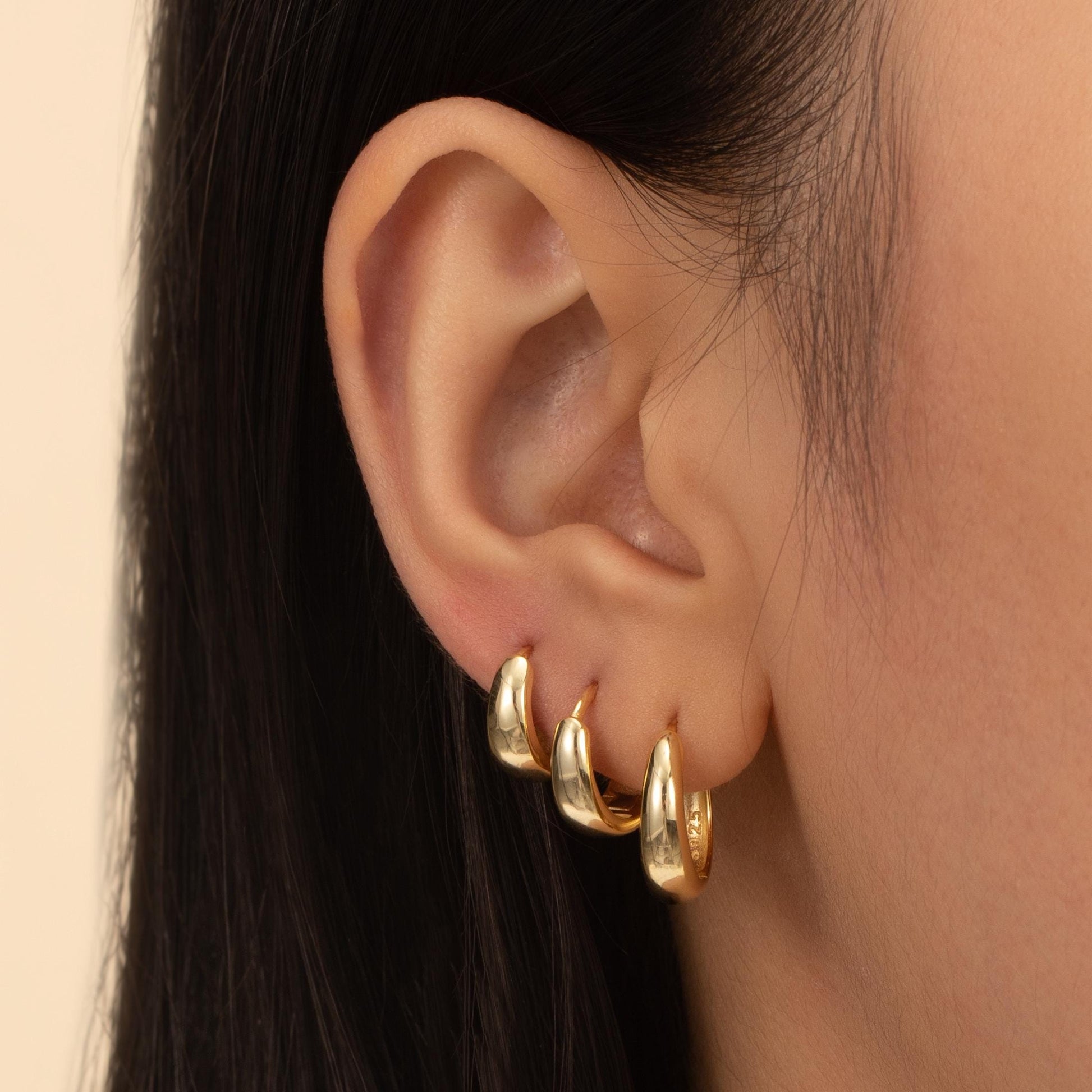 a close up of a person wearing a pair of earrings
