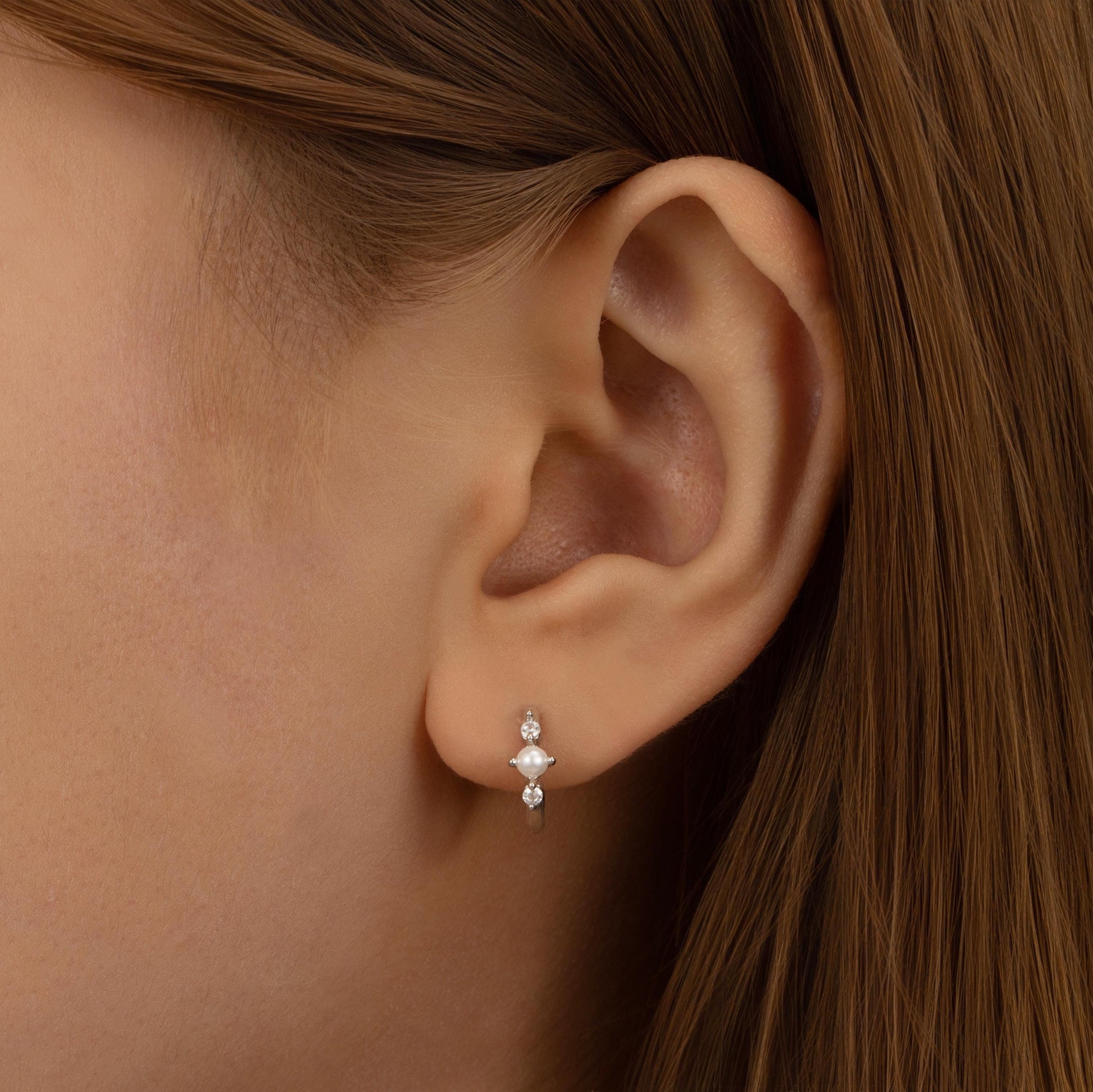 a close up of a person wearing a pair of earrings