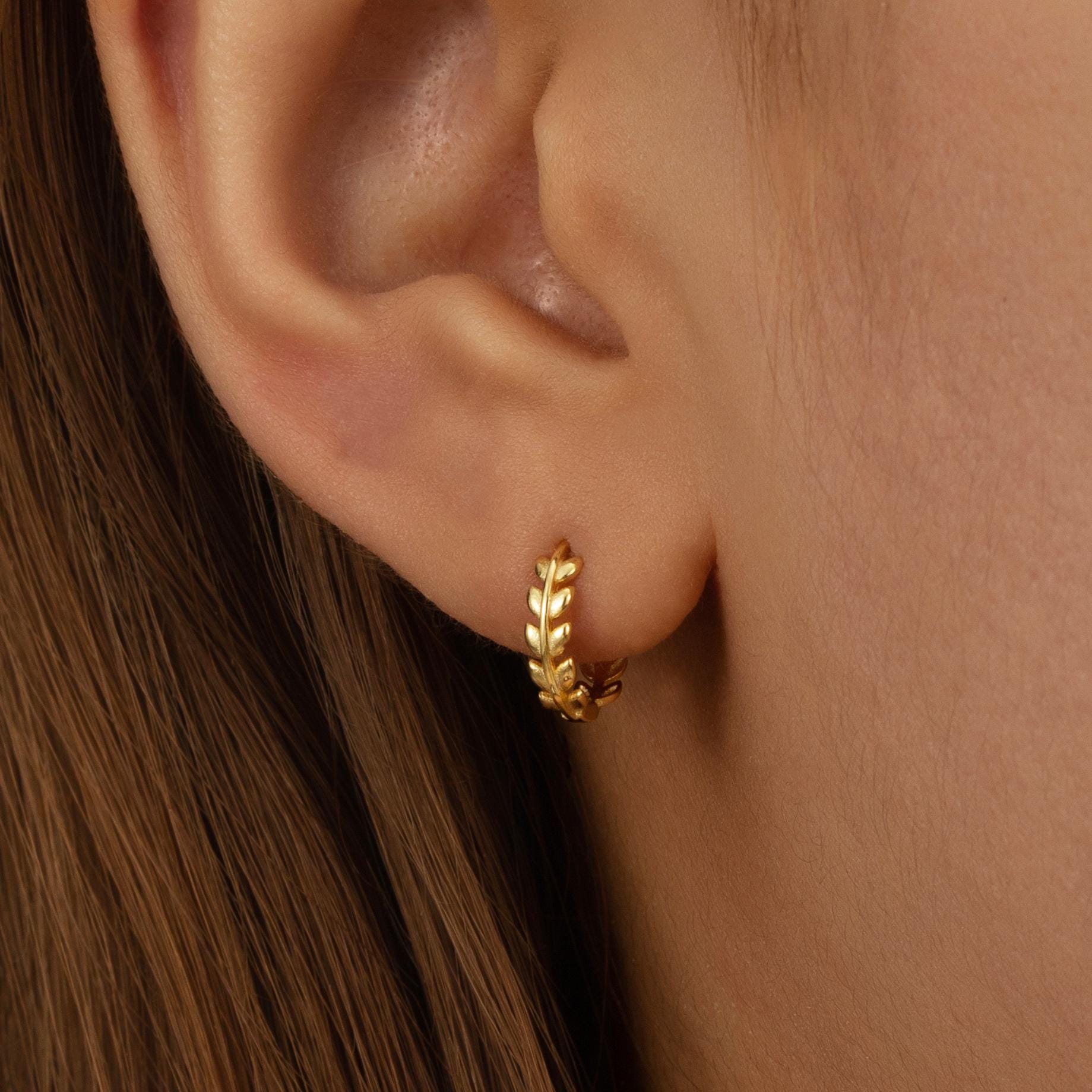 a close up of a person wearing a pair of earrings