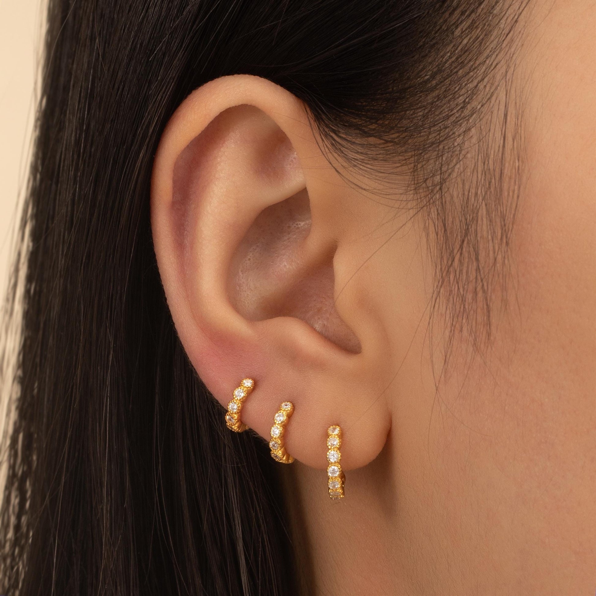 a close up of a person wearing a pair of ear cuffs