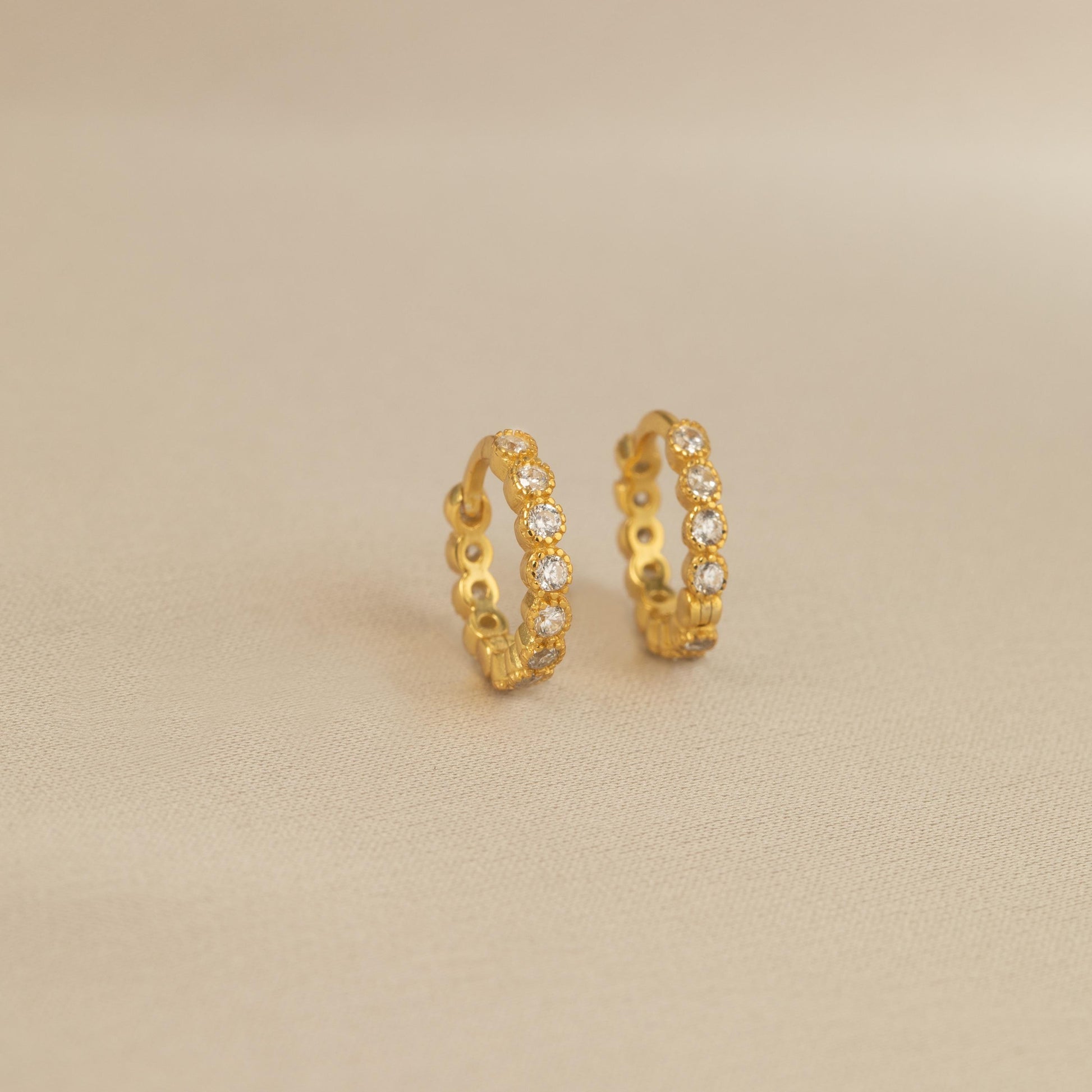 a pair of gold earrings with small diamonds