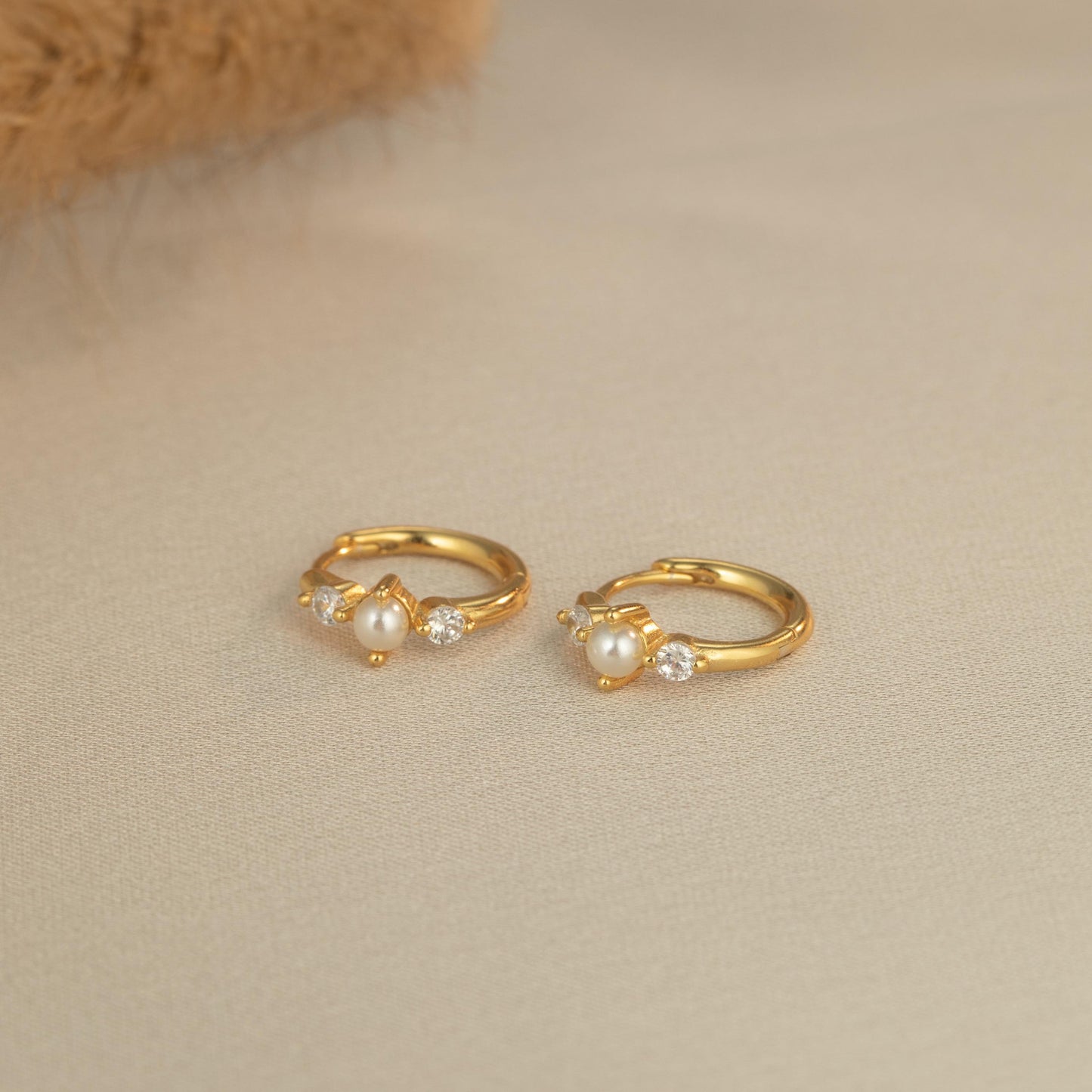 a pair of gold earrings with pearls