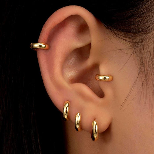 a close up of a person&#39;s ear with three gold colored ear tips
