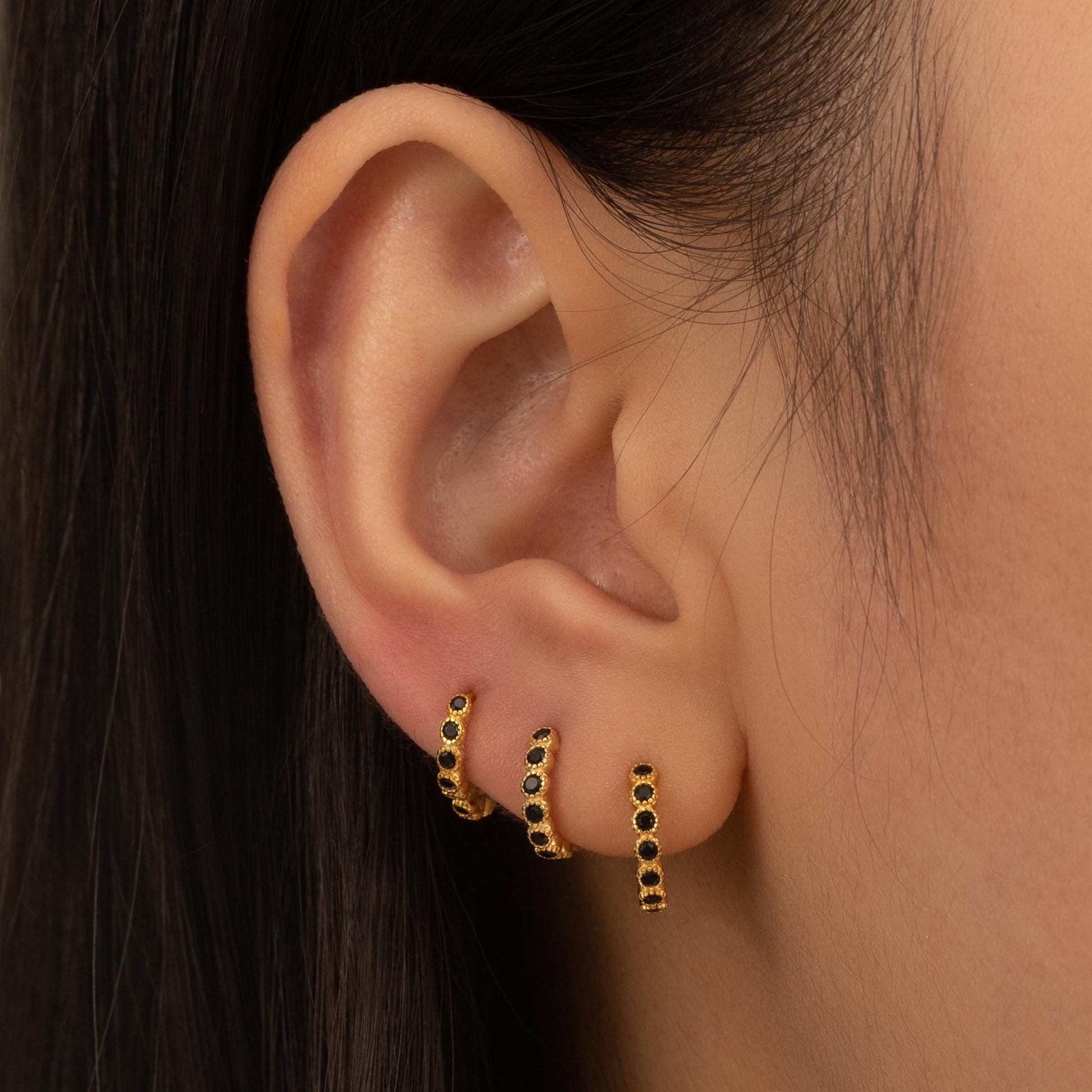 a close up of a person wearing a pair of earrings
