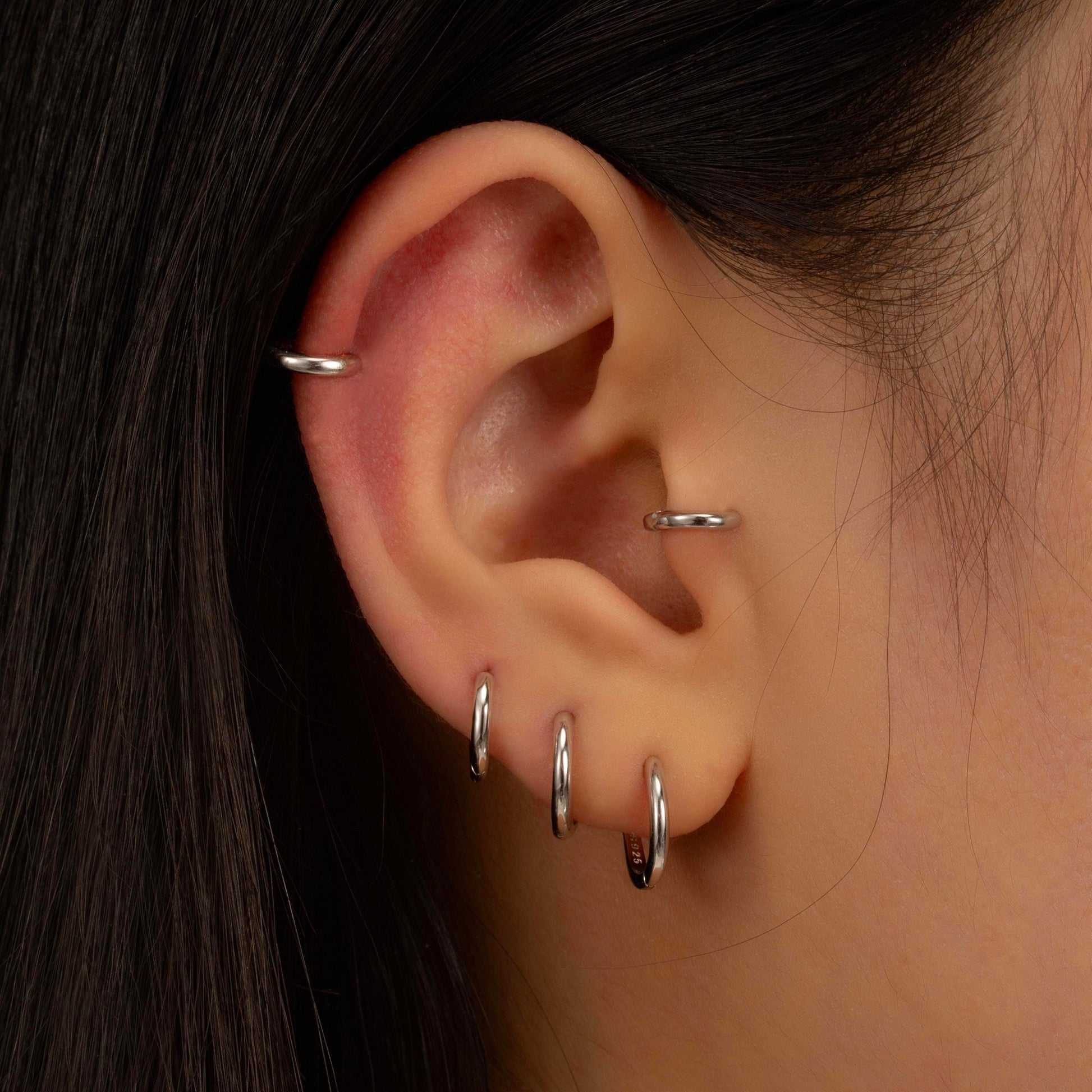 a close up of a person wearing a pair of ear piercings