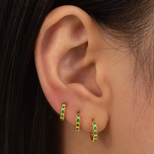a close up of a person wearing a pair of earrings