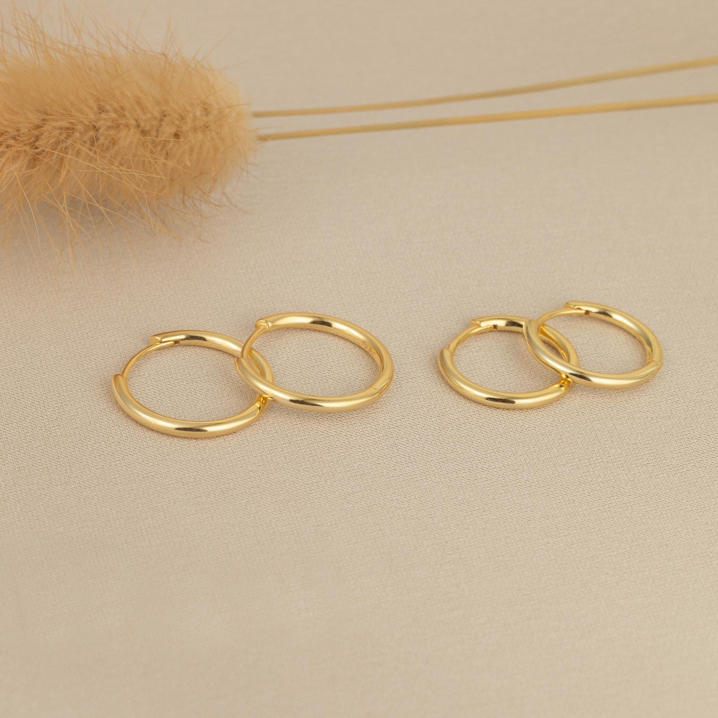 a pair of gold hoop earrings sitting on top of a table