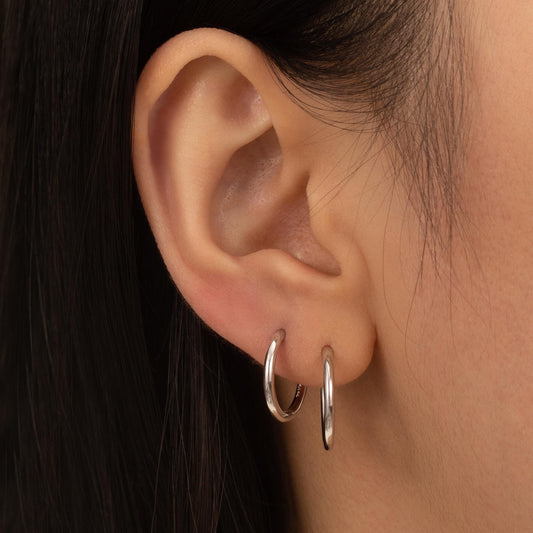 a close up of a person wearing a pair of hoop earrings
