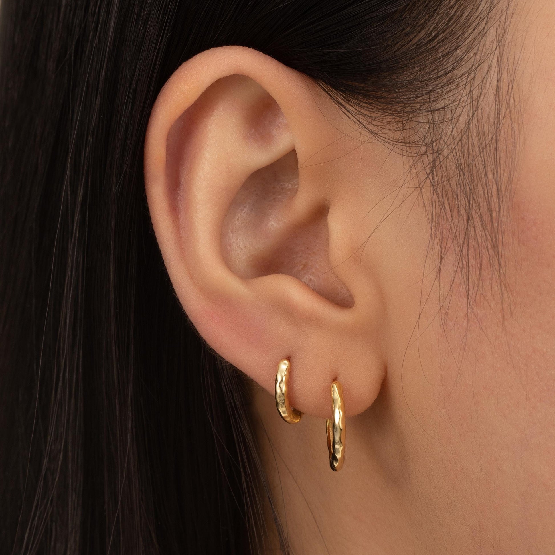 a close up of a person wearing a pair of earrings