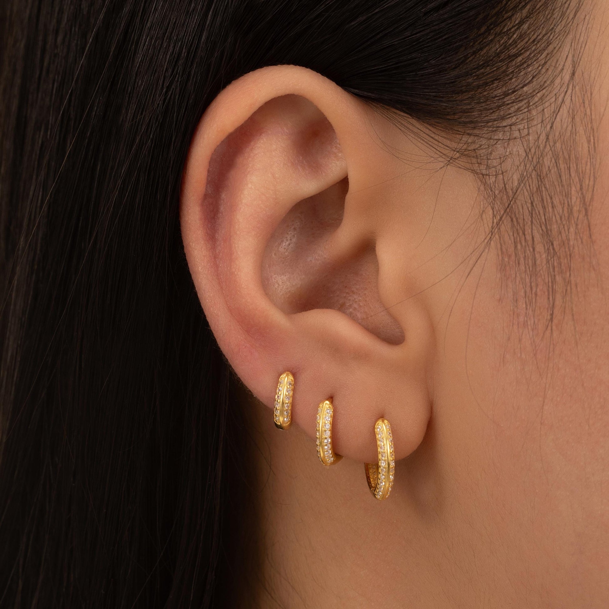 a close up of a person wearing a pair of earrings