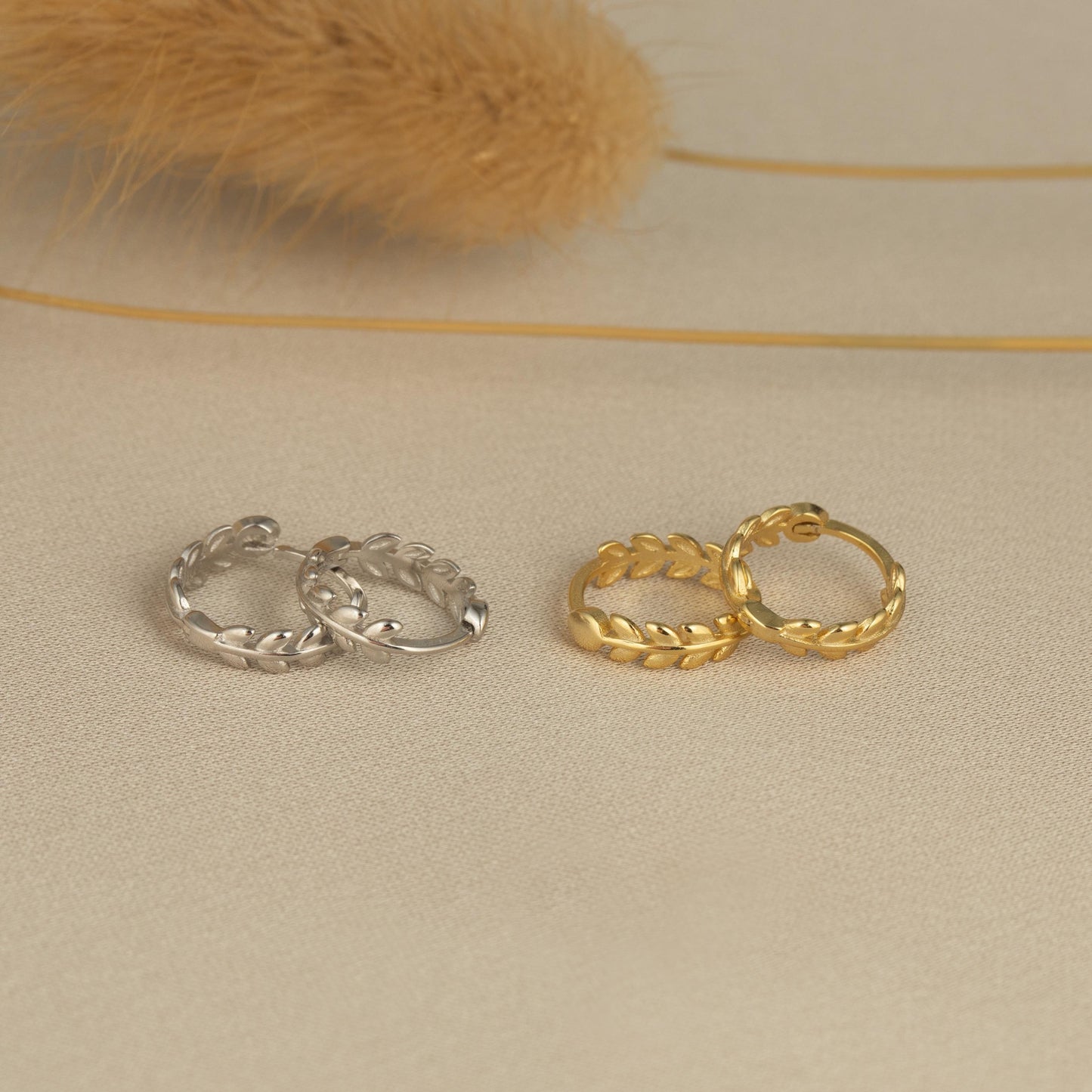 three pairs of gold and silver rings on a white surface