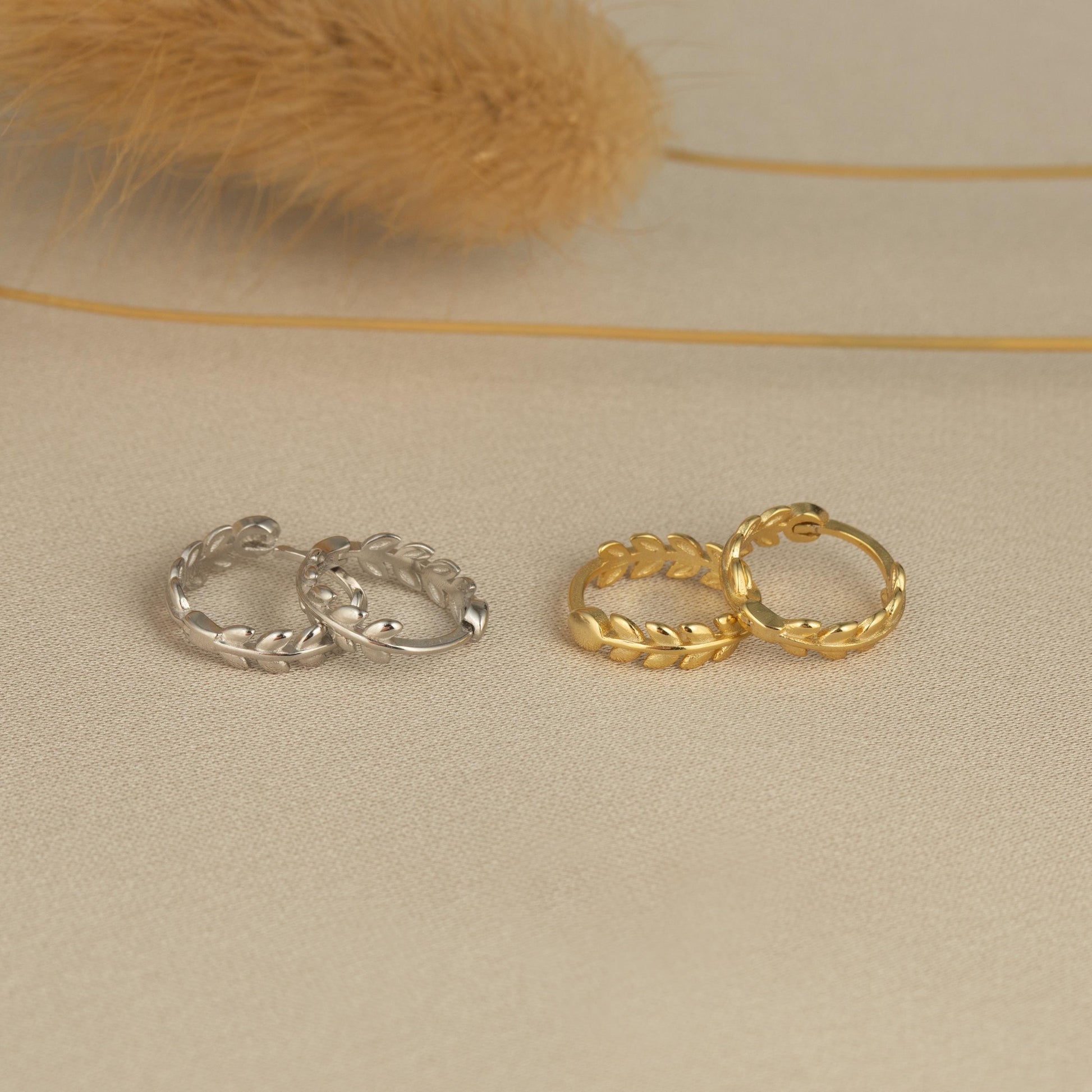 three pairs of gold and silver rings on a white surface
