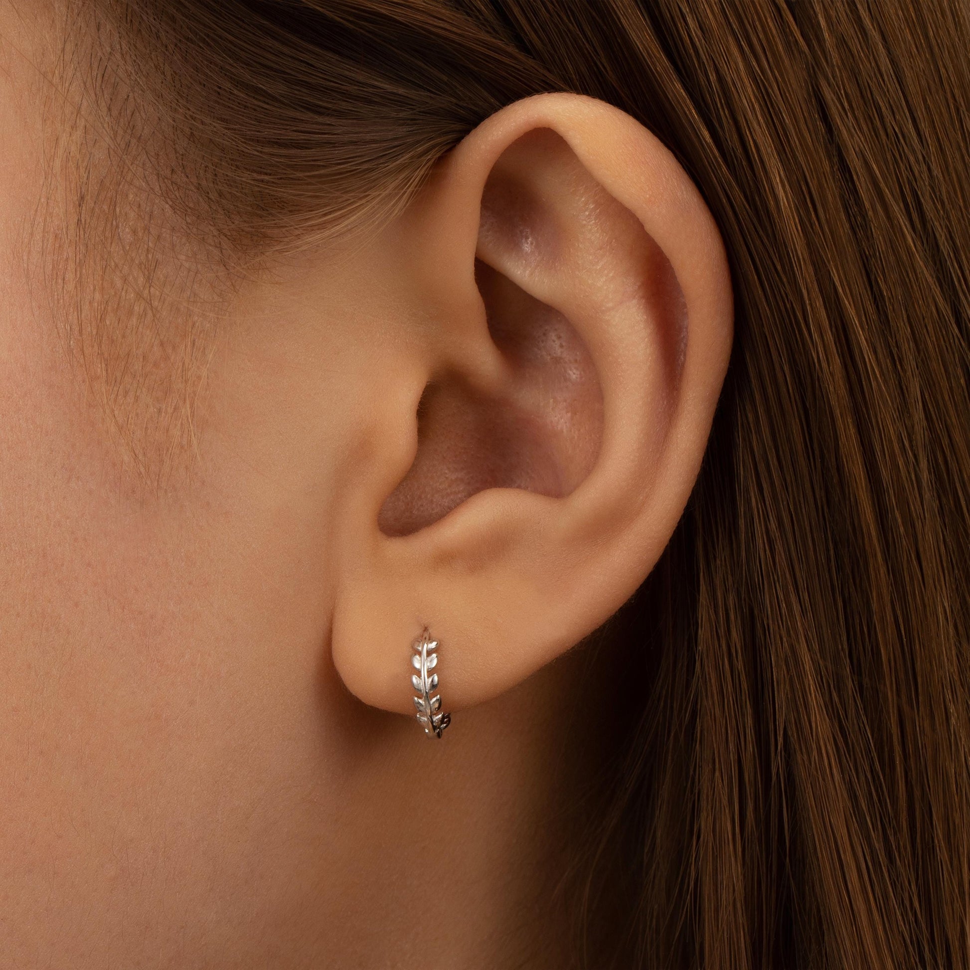 a close up of a person wearing a pair of earrings