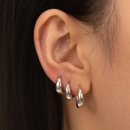 a close up of a person wearing a pair of earrings