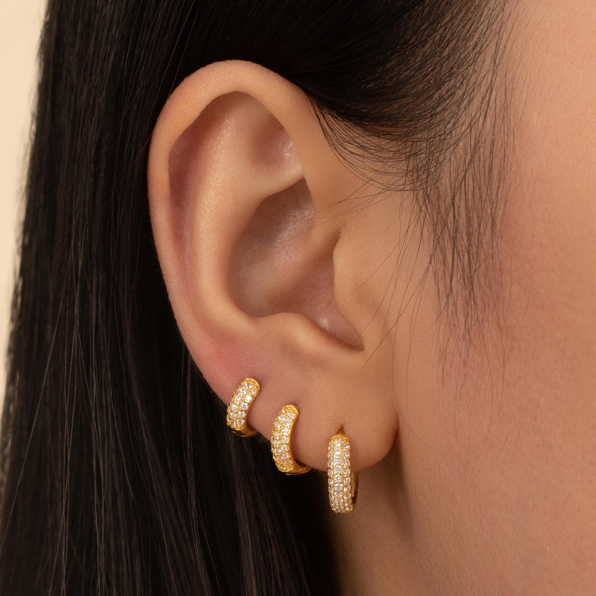 a close up of a person wearing a pair of earrings