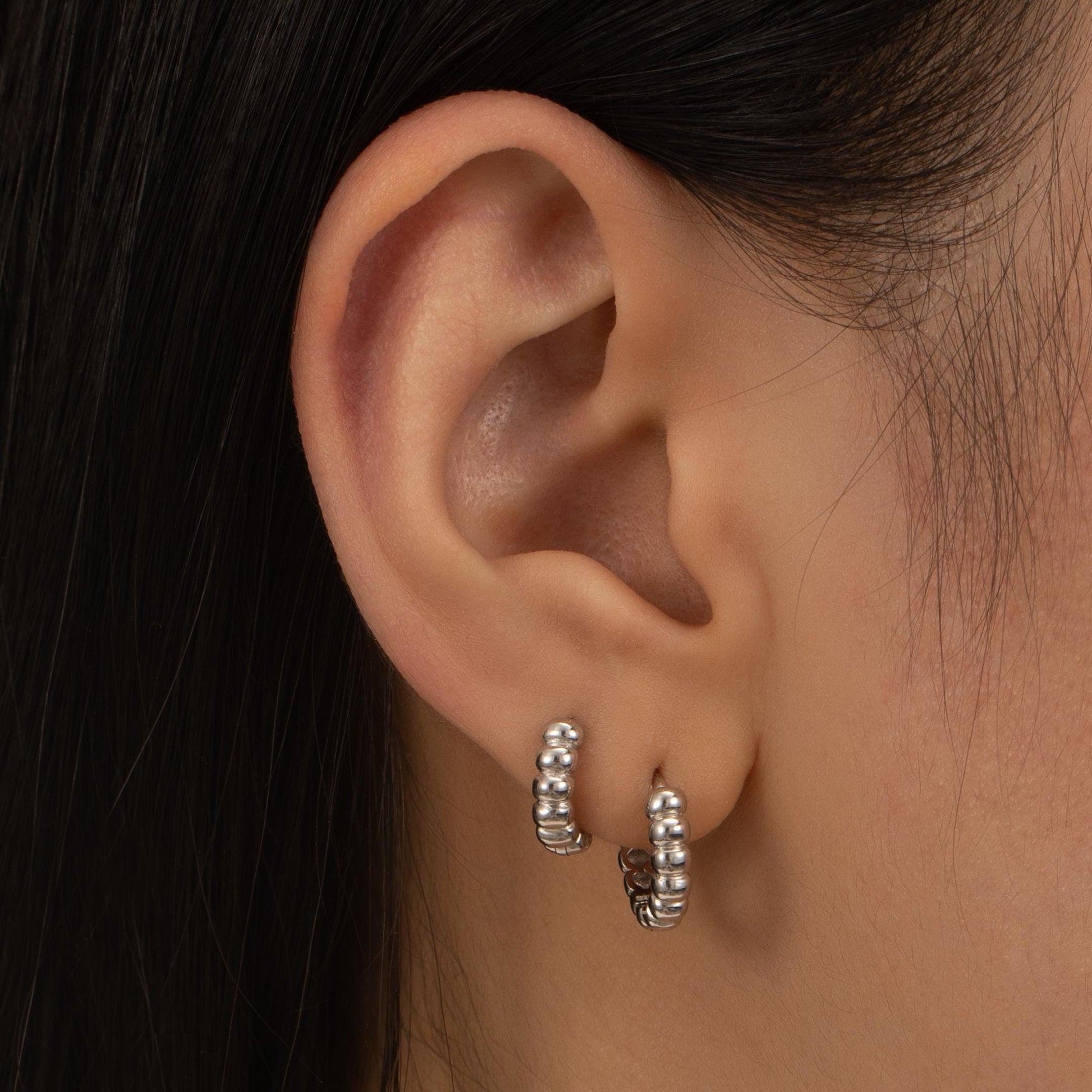 a close up of a person wearing a pair of earrings